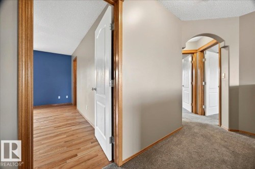 Hallway featuring neutral wall paint, wood-finish flooring, and a carpeted section - 11824 13 Avenue, Edmonton, AB - Indoor Photo Showing Other Room