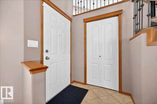 Foyer featuring an entry door with sidelight, bi-fold closet doors, and wood-finish trim - 11824 13 Avenue, Edmonton, AB - Indoor Photo Showing Other Room