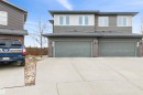 The property exterior features a contemporary design with dual garages, a paved driveway, and horizontal siding in varying shades - 607 40 Street Sw, Edmonton, AB  - Outdoor 