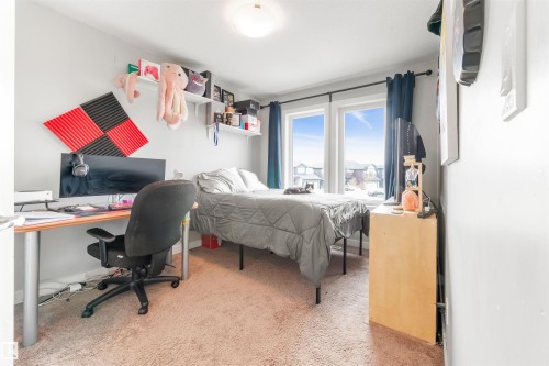 This room features light-colored walls, carpeted flooring, and a large window providing natural light - 607 40 Street Sw, Edmonton, AB - Indoor Photo Showing Bedroom