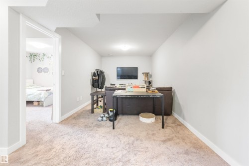This versatile space features carpeting and light-colored walls, with an opening leading to an additional room - 607 40 Street Sw, Edmonton, AB - Indoor Photo Showing Office