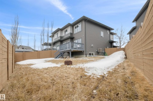 The property features a private backyard with a wooden fence, a deck with stairs, and a fire pit - 607 40 Street Sw, Edmonton, AB - Outdoor With Exterior