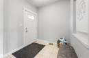 The entryway features a white door with a window panel, light-colored tile flooring, and light gray walls - 607 40 Street Sw, Edmonton, AB  - Indoor Photo Showing Other Room 