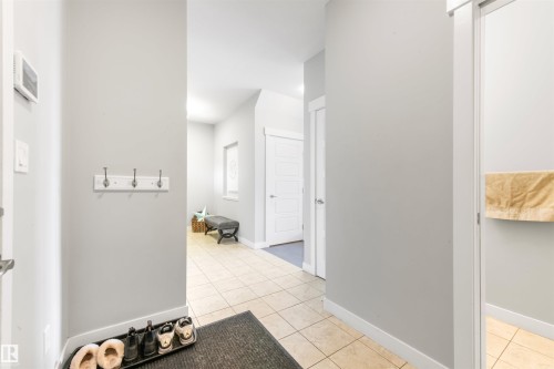 Entryway featuring tiled flooring, light-colored walls, and a coat rack with three hooks - 607 40 Street Sw, Edmonton, AB - Indoor Photo Showing Other Room