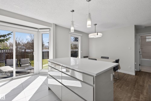 Modern kitchen island with a light-toned countertop and lower storage - 15251 88A Street, Edmonton, AB - Indoor