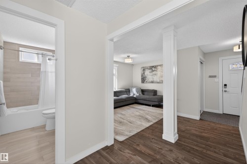 Open-concept living area featuring rich wood-finish flooring, white trim, and light wall tones - 15251 88A Street, Edmonton, AB - Indoor Photo Showing Other Room