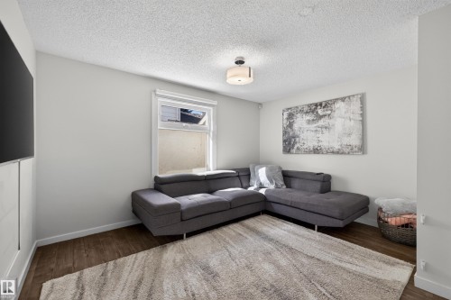 Living area featuring wood-finish flooring, a neutral color palette, and a window for natural light - 15251 88A Street, Edmonton, AB - Indoor Photo Showing Living Room