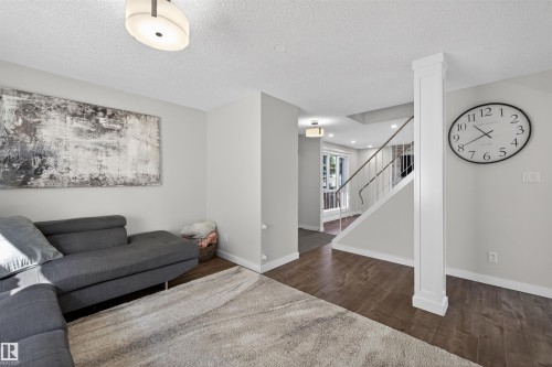 Spacious living area featuring wood-finish flooring and light grey wall tones - 15251 88A Street, Edmonton, AB - Indoor