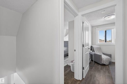Hallway with white painted walls, wood-finish flooring, and white trim - 15251 88A Street, Edmonton, AB - Indoor Photo Showing Other Room
