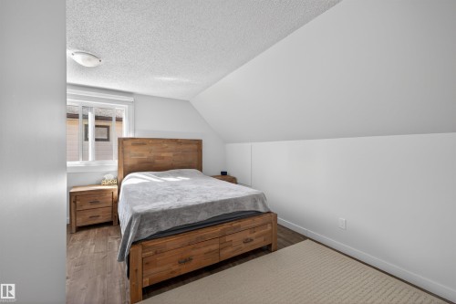 Bedroom featuring wood-finish flooring, a contemporary window, and a sloped ceiling design - 15251 88A Street, Edmonton, AB - Indoor Photo Showing Bedroom