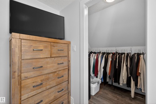 Walk-in closet featuring wood-finish flooring and ample hanging space - 15251 88A Street, Edmonton, AB - Indoor