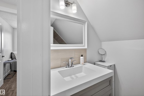 Bathroom vanity featuring a white rectangular undermount sink, chrome faucet, and integrated white countertop - 15251 88A Street, Edmonton, AB - Indoor Photo Showing Other Room