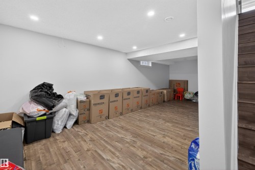 Lower level space featuring wood-finish flooring, recessed lighting, white walls, and a window well - 15251 88A Street, Edmonton, AB - Indoor