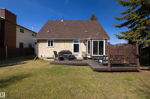 Expansive rear yard featuring a dark wood-finish deck with privacy lattice, a bay window, and sliding glass door access to the interior - 15251 88A Street, Edmonton, AB - Outdoor With Exterior