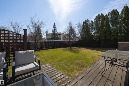 Expansive backyard featuring a dark wood-finish deck, a manicured lawn, and a privacy fence - 15251 88A Street, Edmonton, AB - Outdoor With Deck Patio Veranda With Backyard