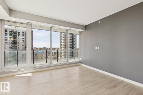 Expansive window wall with a glass balcony railing - #1601 10180 103 St Nw, Edmonton, AB - Indoor Photo Showing Other Room