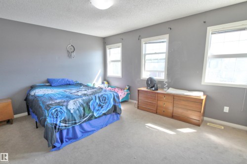 Spacious room featuring neutral carpeting and a ceiling-mounted light fixture - 14820 140 Street, Edmonton, AB - Indoor Photo Showing Bedroom