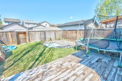 Backyard featuring a wooden privacy fence and a grassy area - 