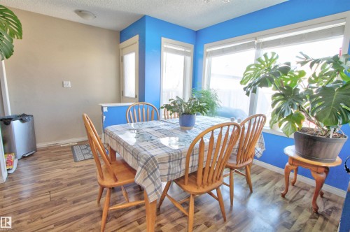 Dining area with wood-finish flooring and a bright blue accent wall - 14820 140 Street, Edmonton, AB - Indoor Photo Showing Dining Room