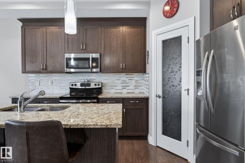 Kitchen featuring wood-finish cabinetry, granite countertops, and a full stainless steel appliance package - 83 Sandalwood Place, Leduc, AB - Indoor Photo Showing Kitchen With Double Sink With Upgraded Kitchen