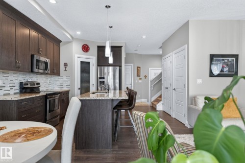 Kitchen featuring wood-finish cabinetry, granite countertops, and stainless steel appliances - 83 Sandalwood Place, Leduc, AB - Indoor Photo Showing Kitchen With Upgraded Kitchen