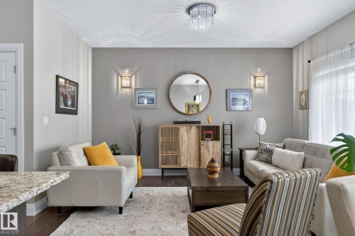Living space featuring wood-finish flooring, light grey walls, and a textured ceiling - 83 Sandalwood Place, Leduc, AB - Indoor Photo Showing Other Room