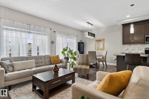 Open-concept living area featuring dark wood-finish flooring - 83 Sandalwood Place, Leduc, AB - Indoor Photo Showing Living Room