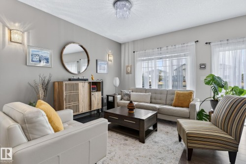 Bright living area featuring a large window, recessed lighting, and dark wood-finish flooring - 83 Sandalwood Place, Leduc, AB - Indoor Photo Showing Living Room