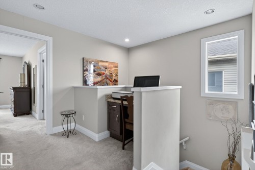 Built-in desk area with a granite countertop, recessed lighting, and carpeting throughout - 83 Sandalwood Place, Leduc, AB - Indoor