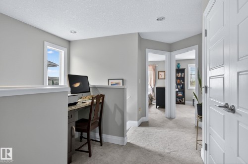 Carpeted hallway with light gray walls and white trim - 83 Sandalwood Place, Leduc, AB - Indoor