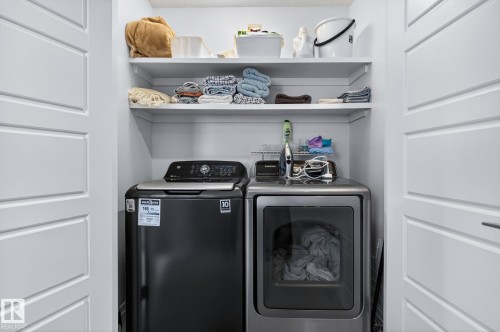 Dedicated laundry area featuring white shelving - 83 Sandalwood Place, Leduc, AB - Indoor Photo Showing Laundry Room