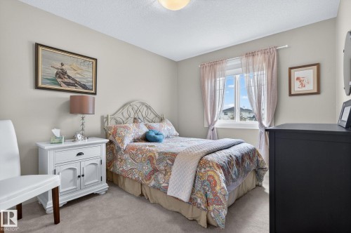 Bright room featuring a window with natural light, light neutral wall paint, and a textured ceiling - 83 Sandalwood Place, Leduc, AB - Indoor Photo Showing Bedroom