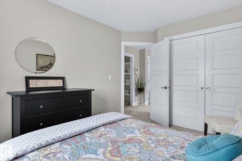 Neutral paint colors throughout, featuring a pair of paneled interior doors with brushed nickel hardware - 83 Sandalwood Place, Leduc, AB - Indoor Photo Showing Bedroom