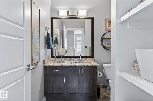 Bathroom vanity with a granite countertop, undermount sink, and dark wood-finish cabinetry - 83 Sandalwood Place, Leduc, AB - Indoor Photo Showing Bathroom