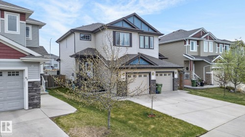 Contemporary two-story residence featuring light-colored siding with dark blue and red gable accents - 83 Sandalwood Place, Leduc, AB - Outdoor With Facade