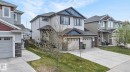 Contemporary two-story residence featuring light-colored siding with dark blue and red gable accents - 83 Sandalwood Place, Leduc, AB  - Outdoor With Facade 