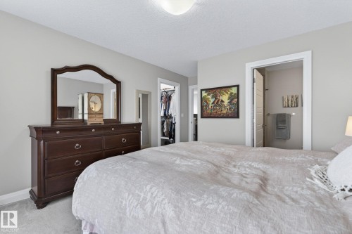 Carpeted bedroom with neutral wall tones and a textured ceiling - 83 Sandalwood Place, Leduc, AB - Indoor Photo Showing Bedroom