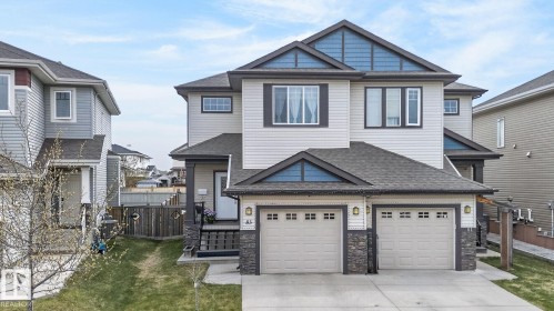 Contemporary two-story residence featuring light-toned siding and blue accent gables - 83 Sandalwood Place, Leduc, AB - Outdoor With Facade