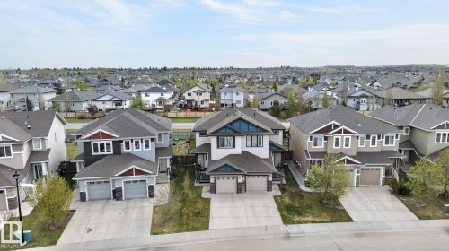 Neighborhood aerial featuring numerous detached residences with integrated garages and paved driveways - 83 Sandalwood Place, Leduc, AB - Outdoor With Facade