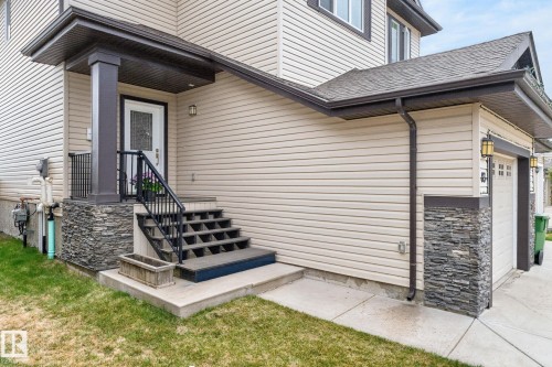 Cream-toned siding exterior with dark trim accents - 83 Sandalwood Place, Leduc, AB - Outdoor