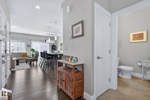 Open-concept living space featuring wood-finish flooring, recessed lighting, and a contemporary kitchen island with pendant lighting - 83 Sandalwood Place, Leduc, AB - Indoor