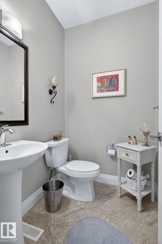 Powder room featuring a pedestal sink, white toilet, and neutral wall paint - 83 Sandalwood Place, Leduc, AB - Indoor Photo Showing Bathroom