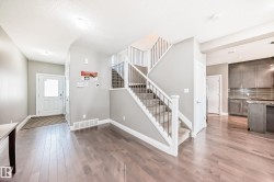 Open concept entryway featuring wood-finish flooring extending into the living spaces - 