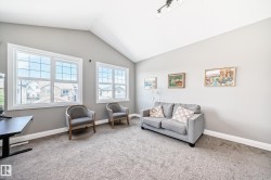Spacious room featuring a vaulted ceiling and neutral-toned walls - 