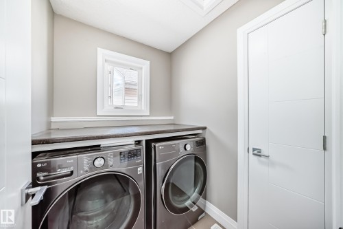 Dedicated laundry area featuring a built-in countertop, light neutral wall paint, and white trim - 4155 Charles Link, Edmonton, AB - Indoor Photo Showing Laundry Room