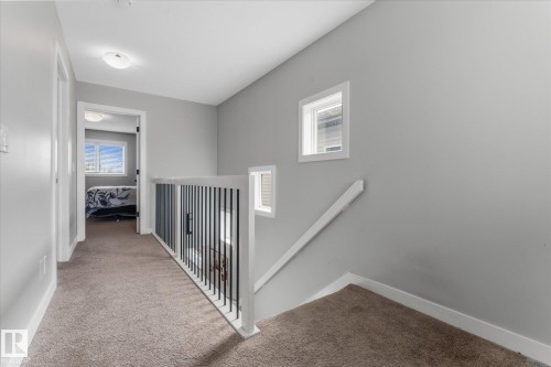 Upper level hallway featuring carpeted flooring, a white spindle railing, and a window providing natural light - 3 Richmond Link, Fort Saskatchewan, AB - Indoor Photo Showing Other Room