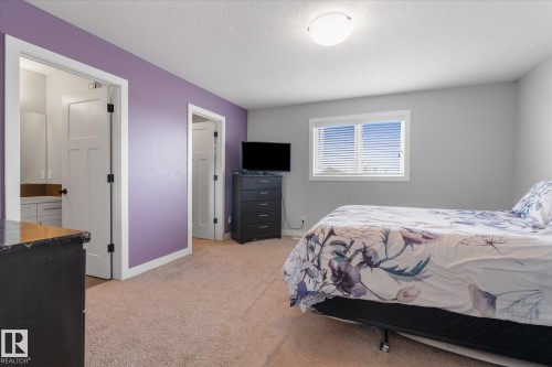 Carpeted bedroom with a window featuring horizontal blinds, recessed ceiling light, and white interior doors - 3 Richmond Link, Fort Saskatchewan, AB - Indoor Photo Showing Bedroom
