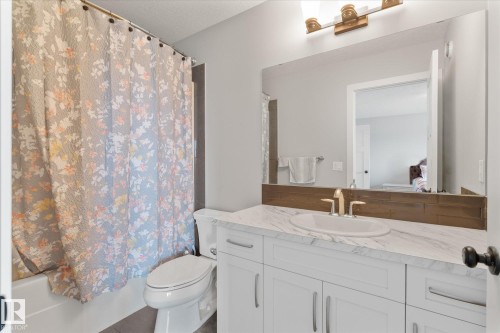 Bathroom with white vanity, integrated sink, and a stone-finish countertop - 3 Richmond Link, Fort Saskatchewan, AB - Indoor Photo Showing Bathroom