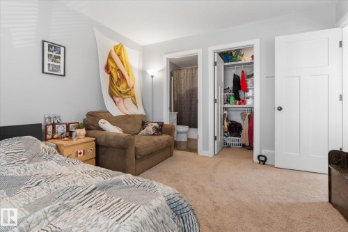 Carpeted room featuring light gray walls, a built-in closet with bifold doors, and a three-panel interior door - 3 Richmond Link, Fort Saskatchewan, AB - Indoor Photo Showing Bedroom