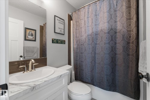 Bathroom featuring a white vanity with a marble-look countertop, undermount sink, and brushed nickel faucet - 3 Richmond Link, Fort Saskatchewan, AB - Indoor Photo Showing Bathroom